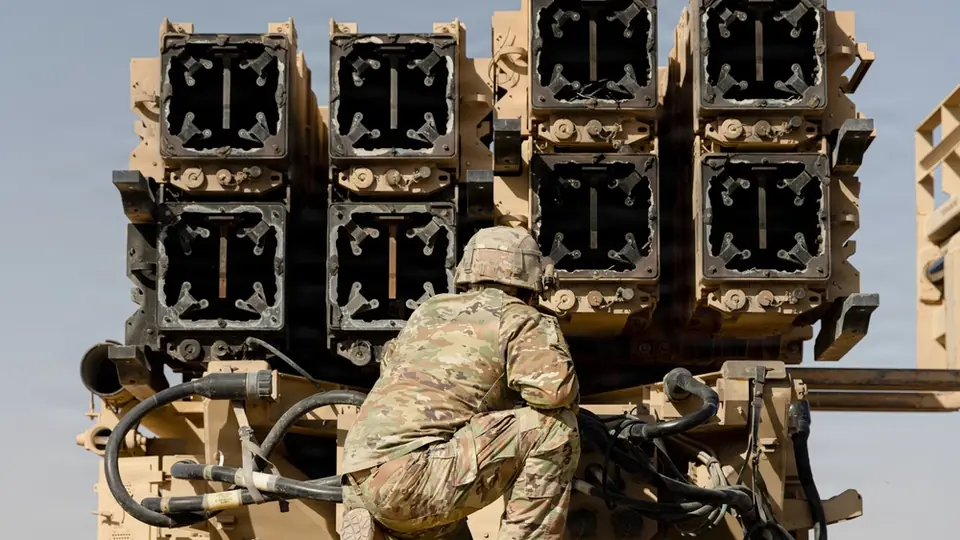 A U.S. Army air defense artilleryman watches spent Patriot interceptors being cross-loaded for transport in the Middle East