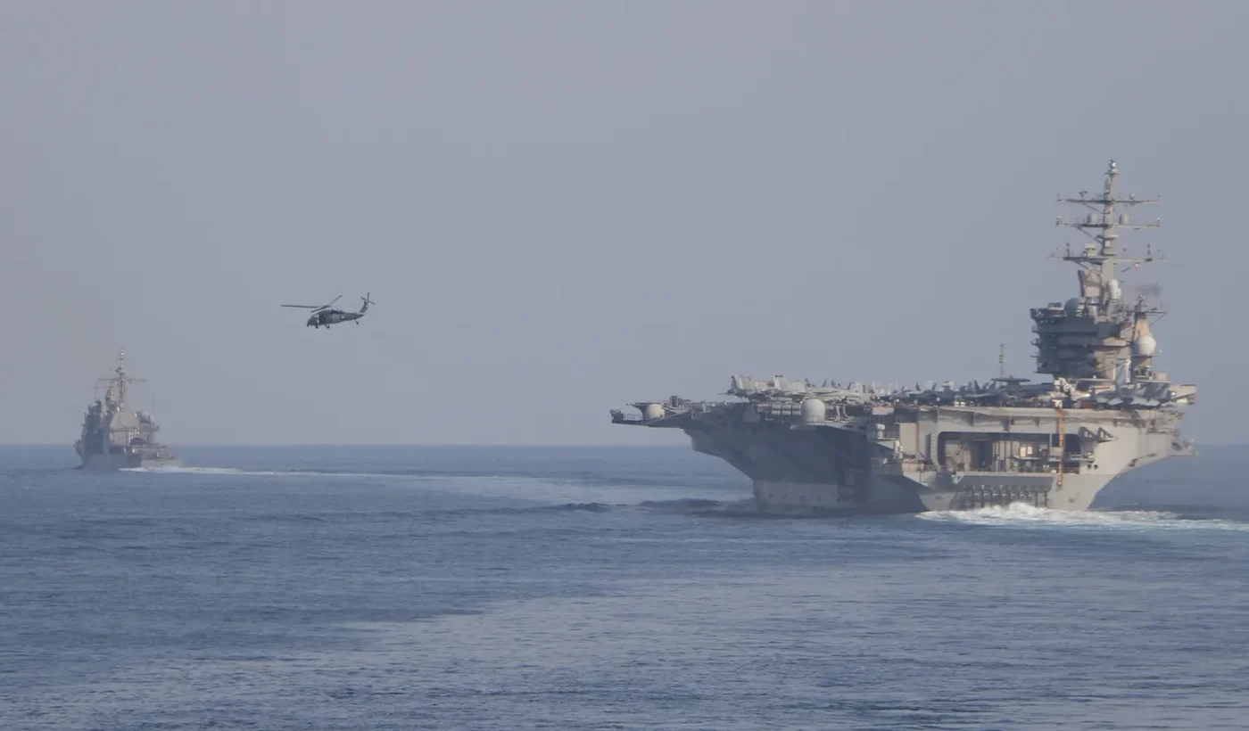 The aircraft carrier USS Dwight D. Eisenhower and escort ships transiting the Strait of Hormuz
