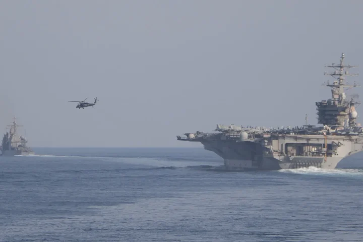 The aircraft carrier USS Dwight D. Eisenhower and escort ships transiting the Strait of Hormuz