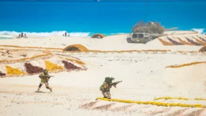 Camouflaged Egyptian soldiers moving across sandy ground during an exercise