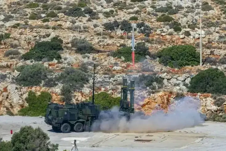 A German-marked IRIS-T SLM launcher fires a missile from a firing position on rocky terrain during an air defence exercise
