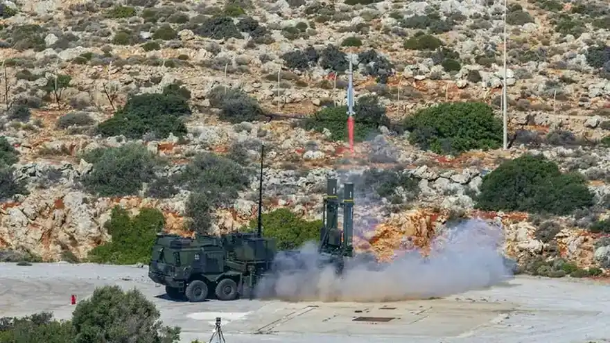 A German-marked IRIS-T SLM launcher fires a missile from a firing position on rocky terrain during an air defence exercise