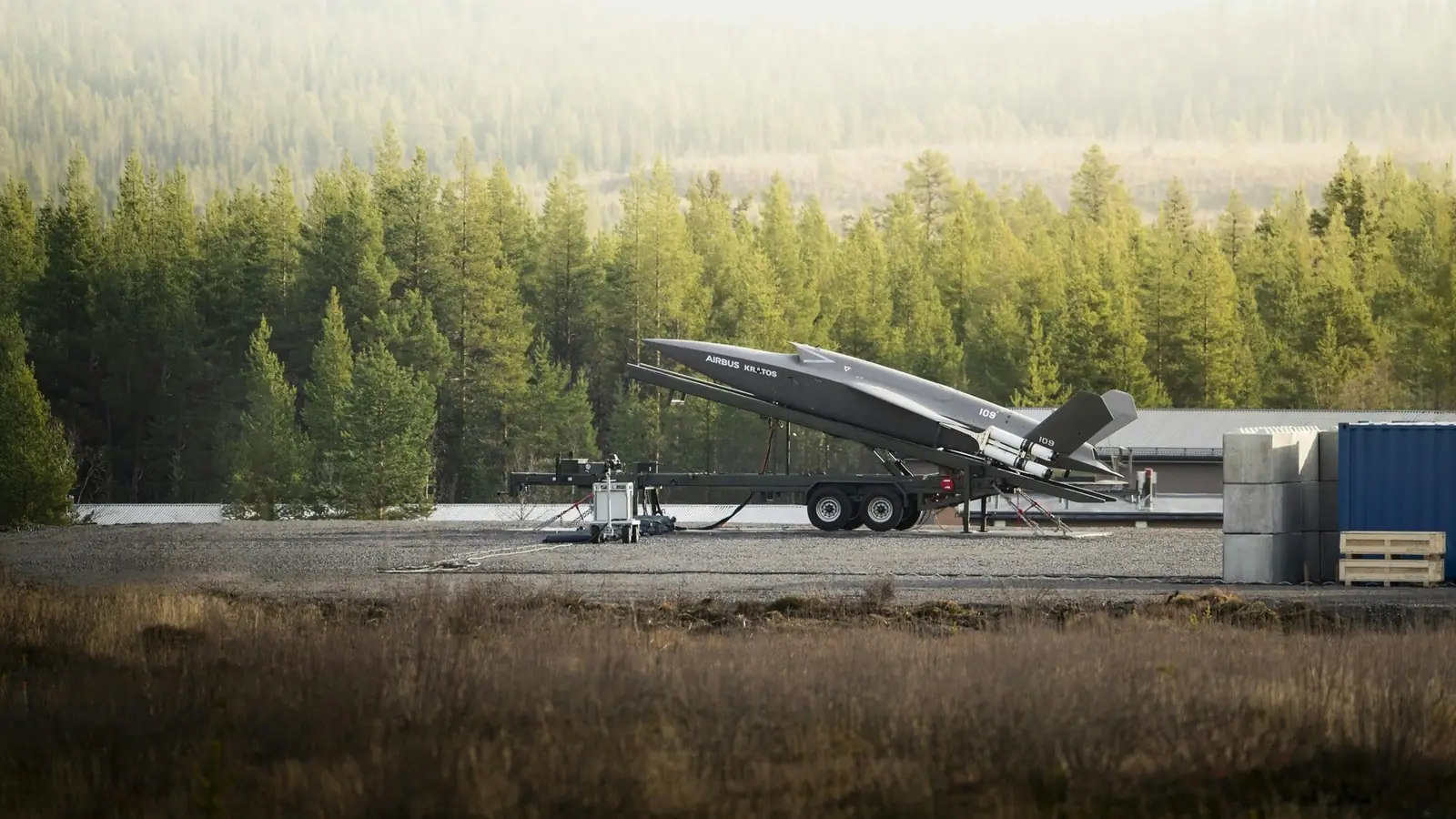 The Airbus U740 Valkyrie on a rail launcher mounted on a trailer, in front of a forest in Northern Europe