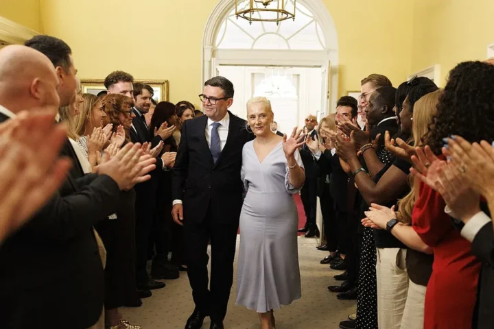 Andy Burnham and his wife Marie-France van Heel walk between applauding staff inside 10 Downing Street