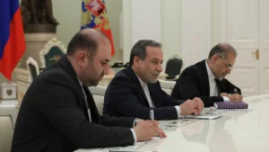 Abbas Araghchi in a dark suit seated at a negotiating table among members of a delegation