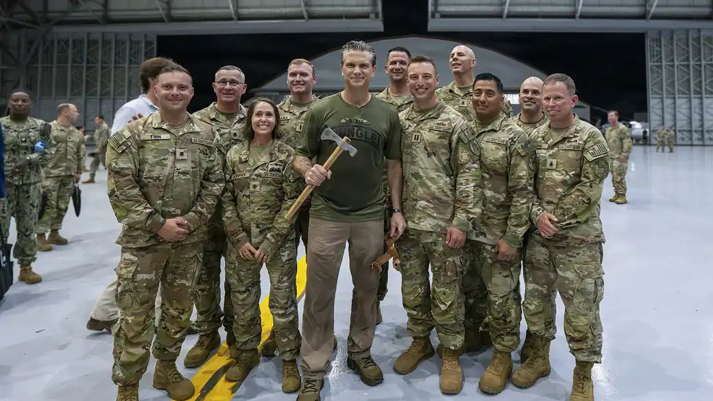 Secretary of War Pete Hegseth stands with a group of U.S. service members in an aircraft hangar during PANAMAX 2026