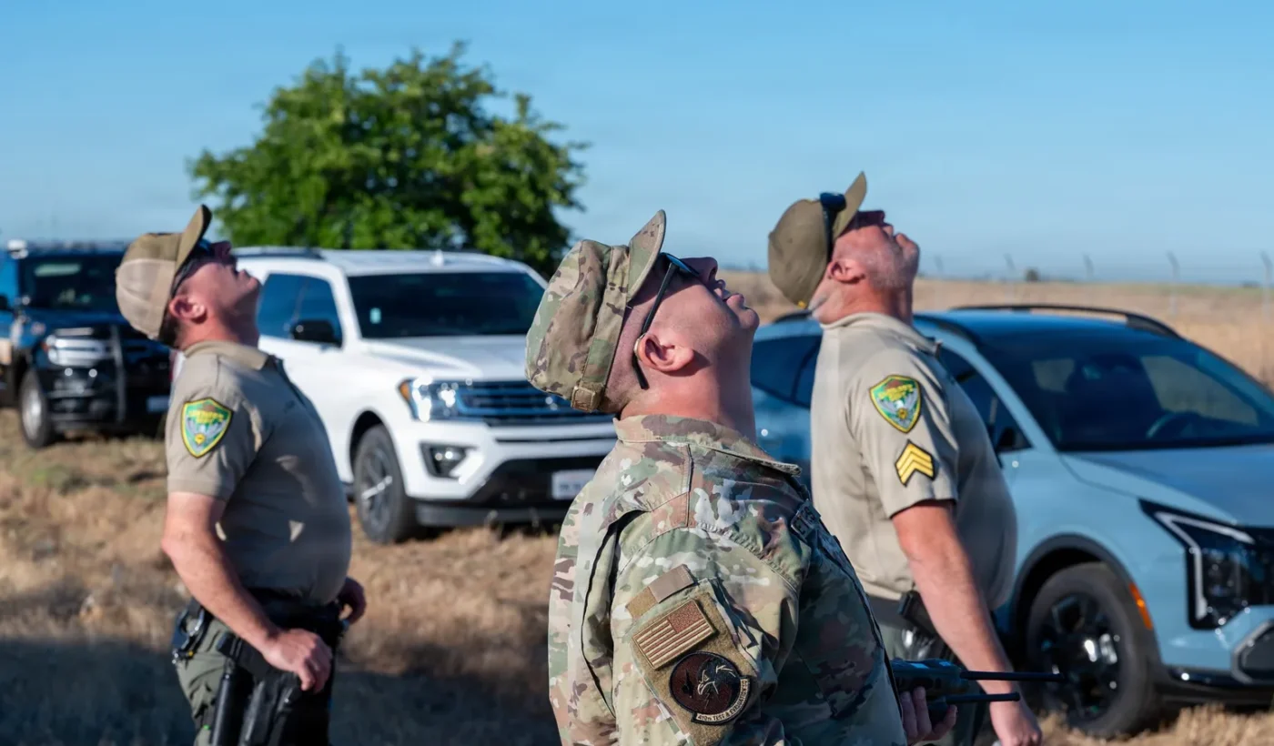 Yuba County deputies and a USAF airman watching a drone land during a counter-small-UAS exercise at Beale Air Force Base, California, June 30, 2026