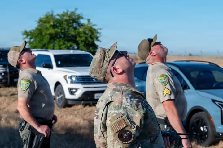 Yuba County deputies and a USAF airman watching a drone land during a counter-small-UAS exercise at Beale Air Force Base, California, June 30, 2026