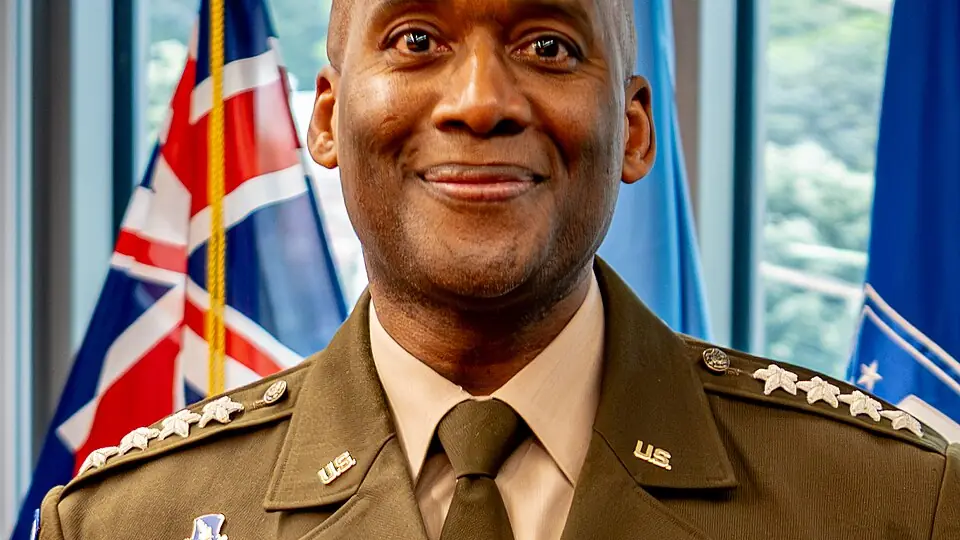 Portrait of General Xavier Brunson in Army service uniform in front of flags