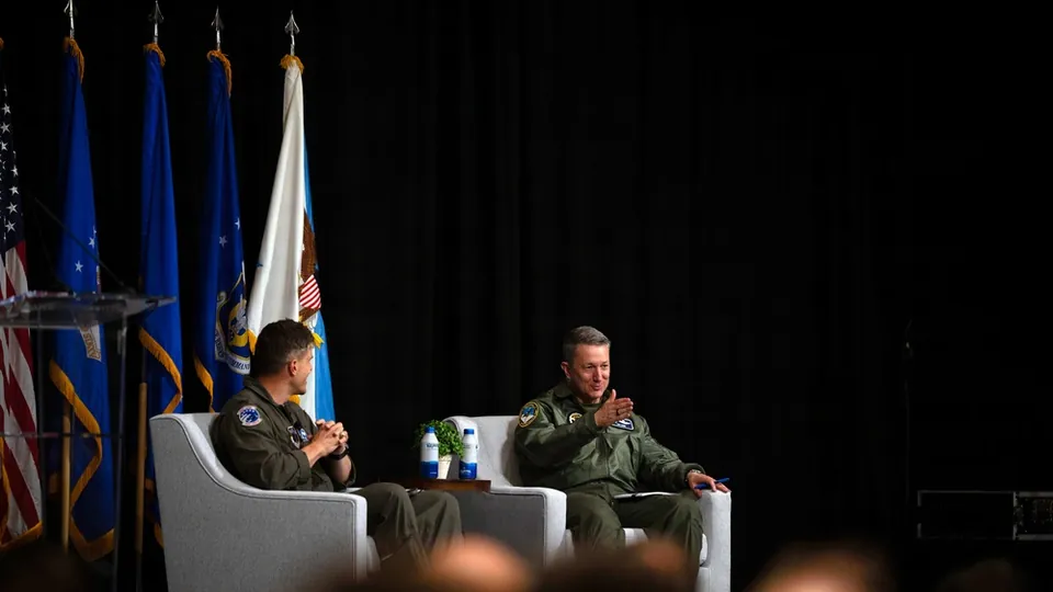 Col. Matthew Tanis and Gen. Dan Caine seated on stage during a fireside chat at the WEPTAC/DCP conference in Tucson, Arizona
