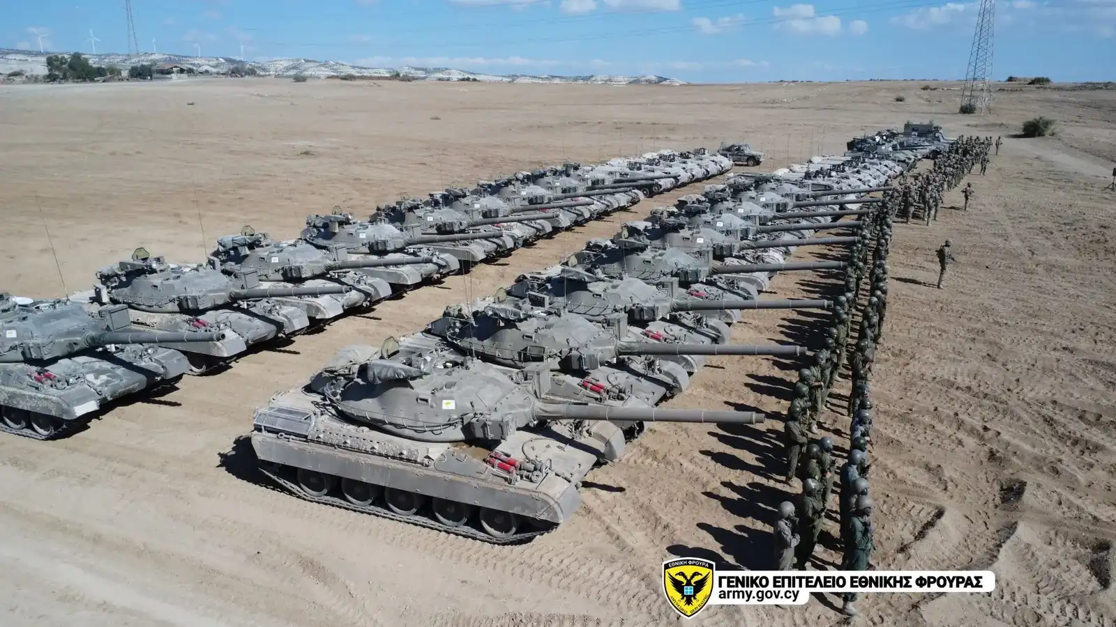 Rows of AMX-30 main battle tanks of the Cypriot National Guard lined up in open terrain, with soldiers standing in formation beside them