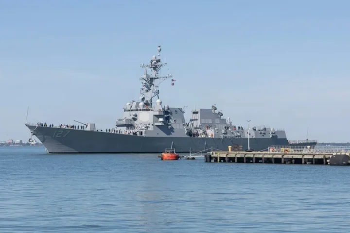 The destroyer DDG 127 alongside a pier at Naval Station Norfolk with sailors on deck