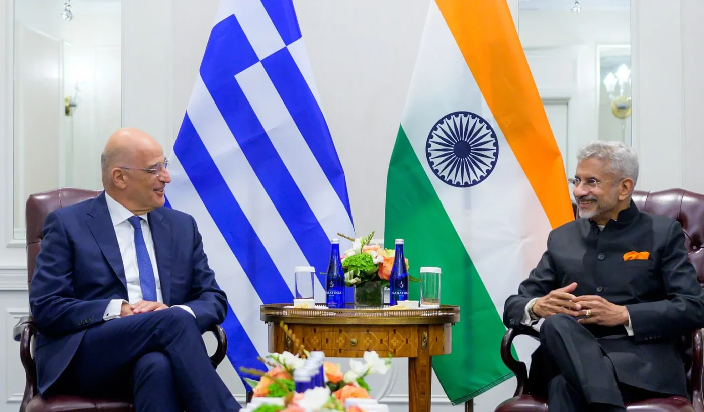 Nikos Dendias and Subrahmanyam Jaishankar talk in front of the flags of Greece and India