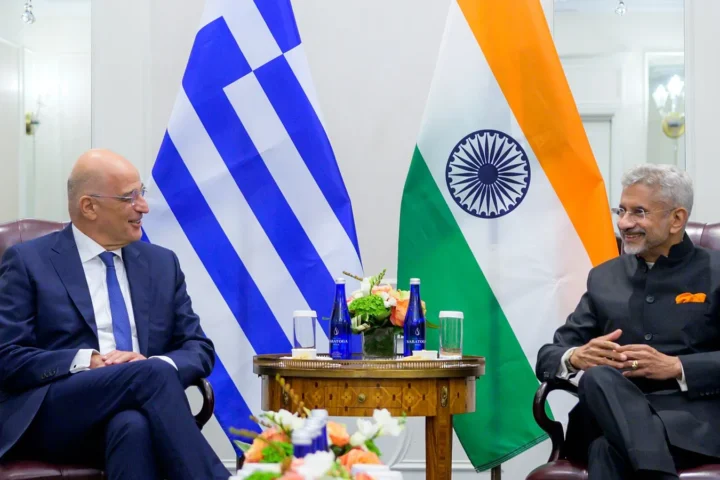 Nikos Dendias and Subrahmanyam Jaishankar talk in front of the flags of Greece and India