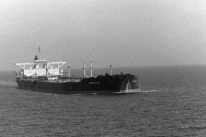 Black-and-white photograph of a large tanker sailing in open sea
