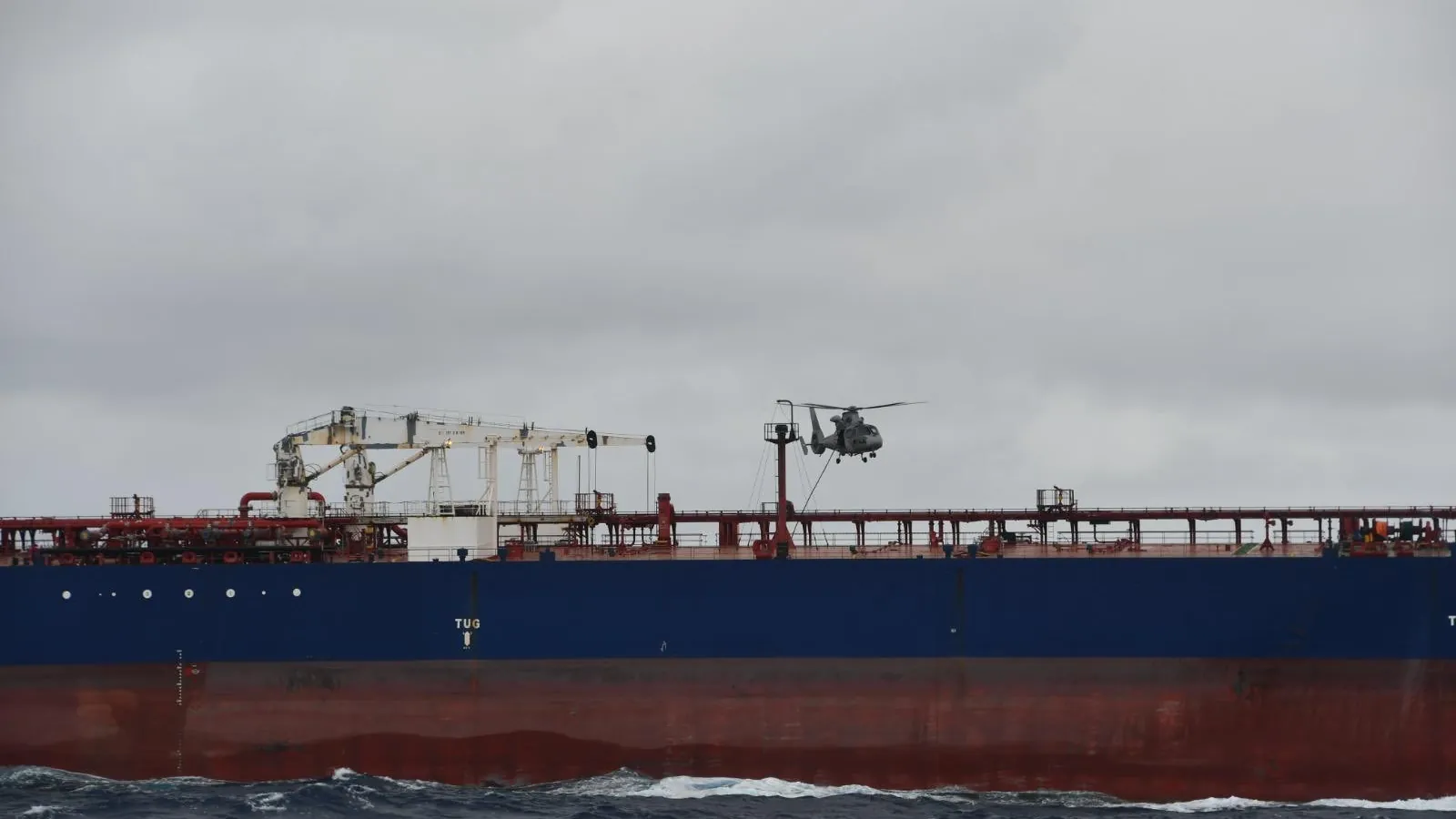 A French Navy helicopter flying over the tanker DF Peak in the Indian Ocean