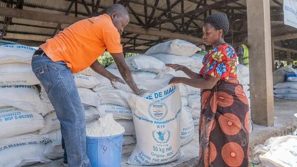 People queue for a food distribution in Rutshuru, eastern DR Congo