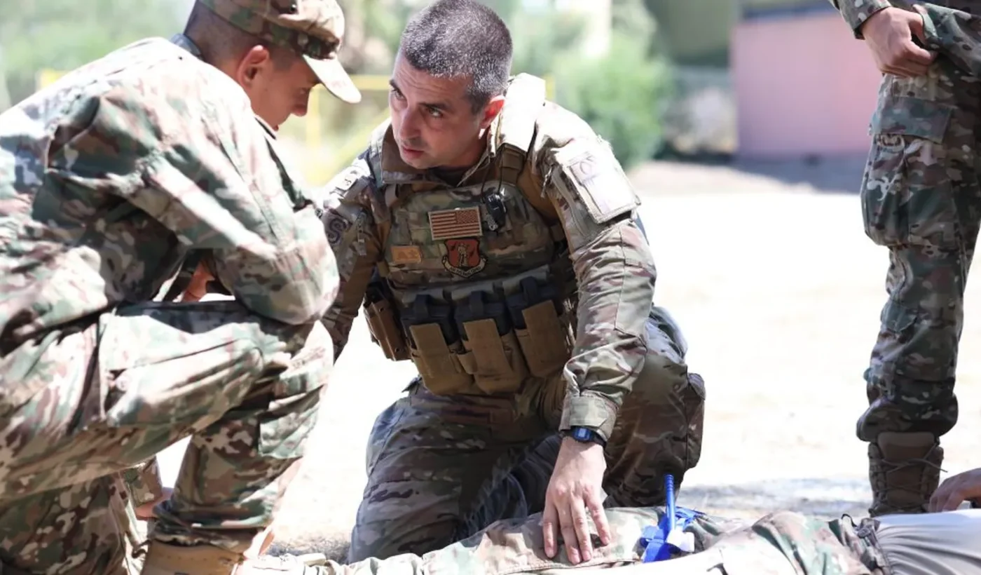 Cyprus National Guard and US service members practising first aid on a casualty on the ground during the TCCC course