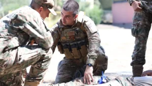 Cyprus National Guard and US service members practising first aid on a casualty on the ground during the TCCC course