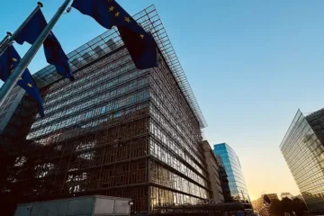 The Europa building in Brussels, seat of the European Council, with EU flags in the foreground