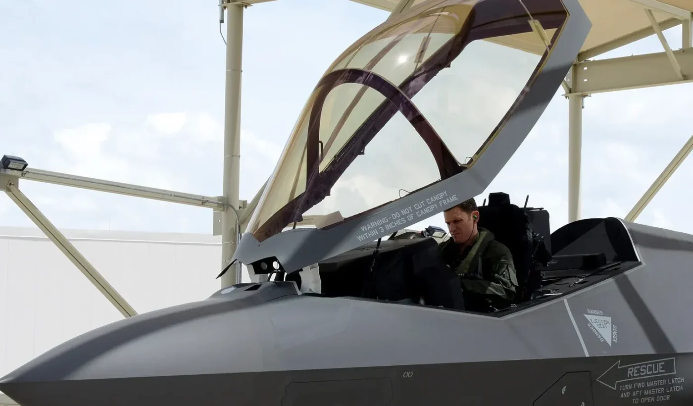 Pilot seated in the open cockpit of an F-35A fighter