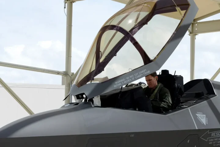 Pilot seated in the open cockpit of an F-35A fighter