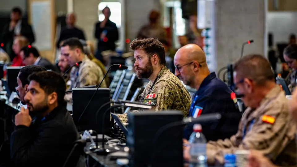 Officers and partners from many nations attend a morning briefing inside the Civil-Military Coordination Center in Kiryat Gat, Israel