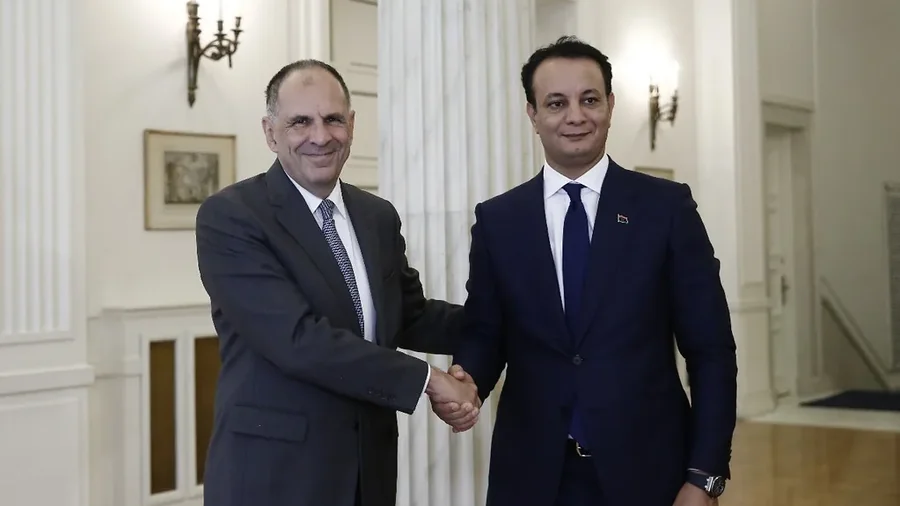 Greek Foreign Minister George Gerapetritis shaking hands with Belgasem Haftar of Libya’s Reconstruction and Development Fund