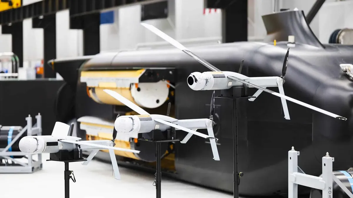 ALTIUS drones in front of a Ghost Shark extra-large autonomous underwater vehicle with the payload bay open