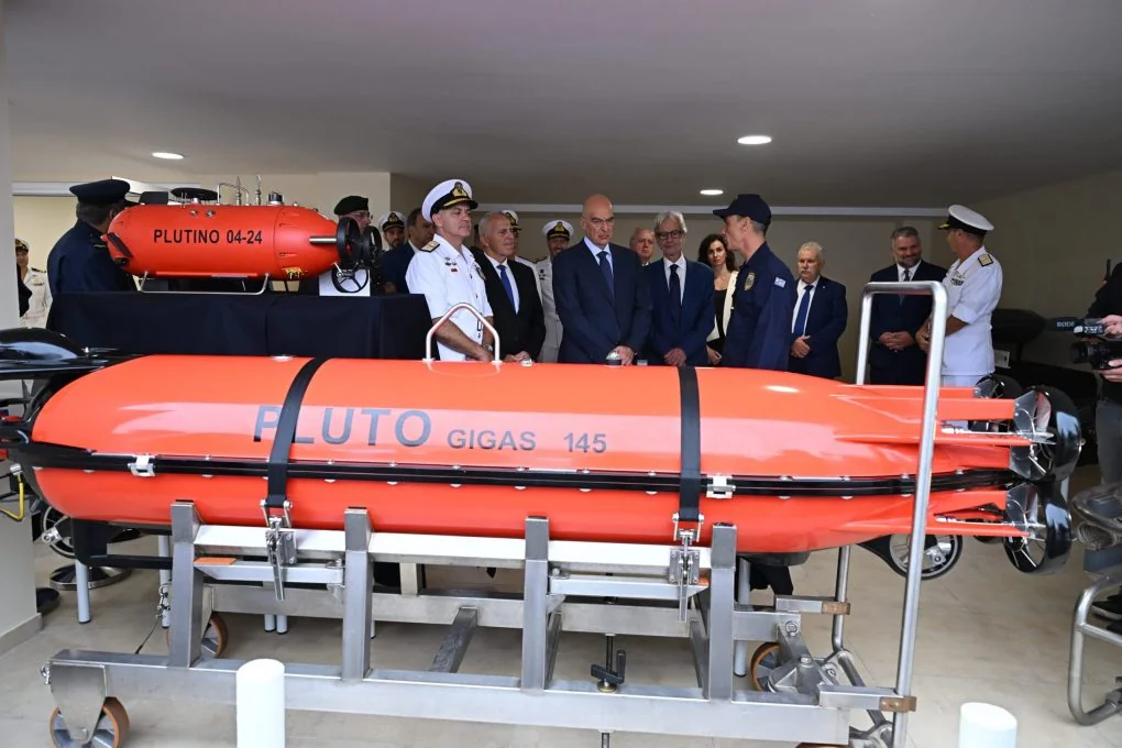 Nikos Dendias and officers behind an orange PLUTO GIGAS underwater vehicle, with the PLUTINO in the background