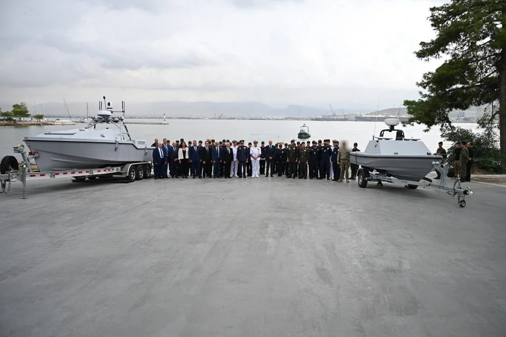 Officials and armed forces officers between the large grey Corsair on the left and the smaller Pyrpolitis on the right