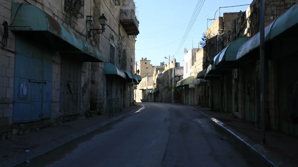 An empty street with closed shops in the old city of Hebron