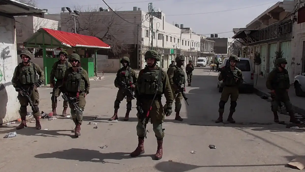 Israeli soldiers standing across a street in Hebron, West Bank, in an archive photo from 2018