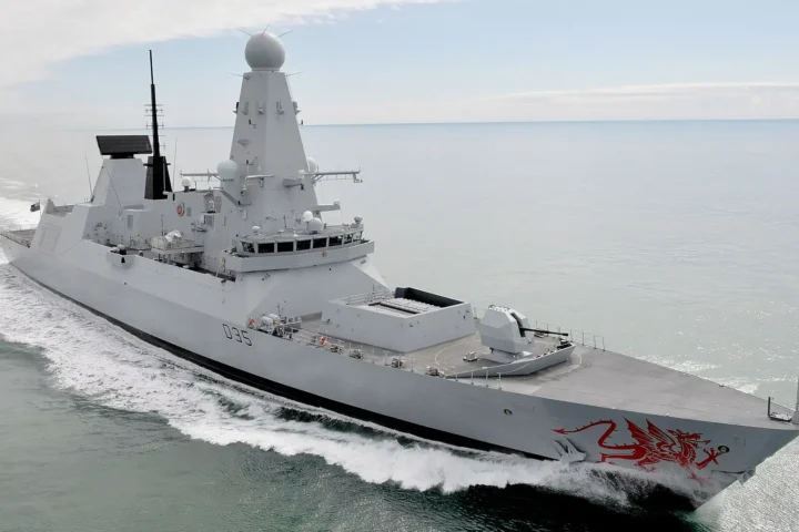 The Royal Navy Type 45 destroyer HMS Dragon, pennant D35, under way at sea with the red Welsh dragon painted on her bow