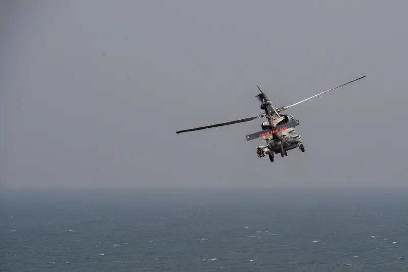 A U.S. Navy MH-60R Sea Hawk helicopter in flight over the waters of the Strait of Hormuz