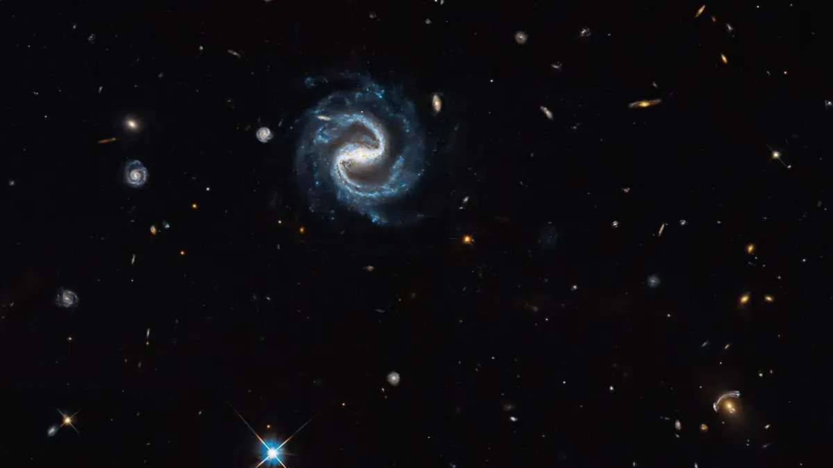 Hubble image of a gravitational lens: an elliptical galaxy bending the light of a more distant galaxy into blue arcs
