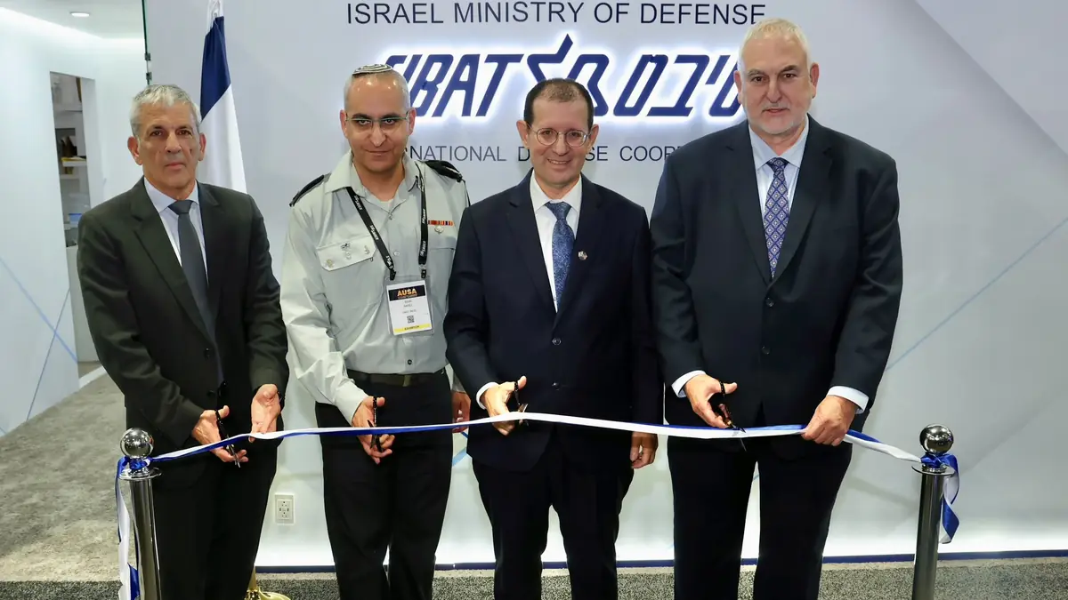 Four men cut a ribbon in front of the Israel Ministry of Defense SIBAT sign at the AUSA exhibition