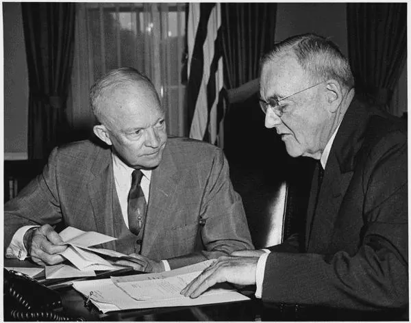 President Dwight D. Eisenhower and Secretary of State John Foster Dulles at a desk in the White House, 1956