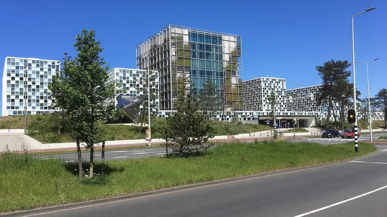 The International Criminal Court building in The Hague, a glass and steel complex under a blue sky