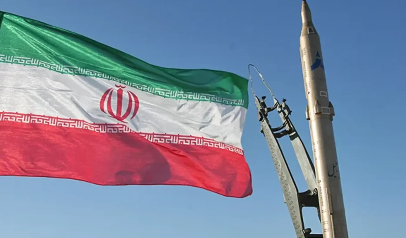 Archival November 2008 photograph of an Iranian flag beside a Sejjil missile on its launch vehicle.