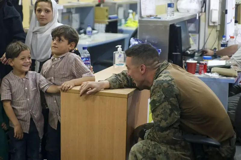 A US Marine with children at Kabul airport during the August 2021 evacuation