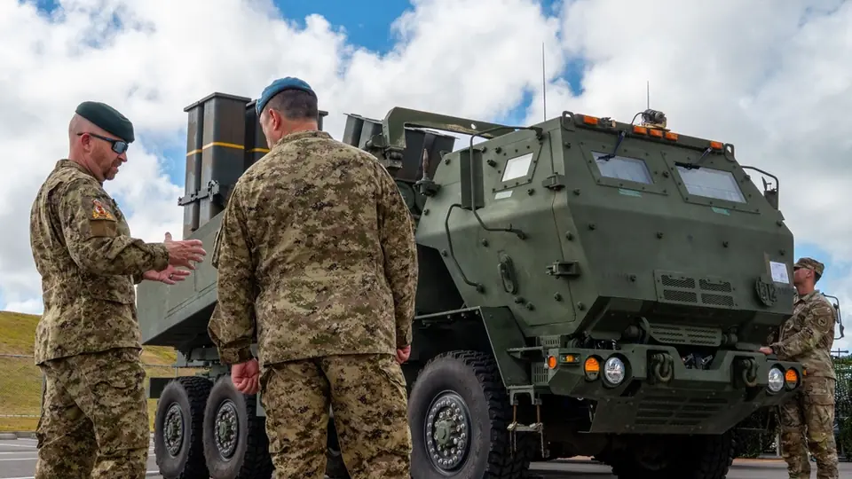 Two Canadian chief warrant officers discuss a U.S. Army HIMARS rocket launcher on static display before the Keen Sword 27 opening ceremony in Ishigaki