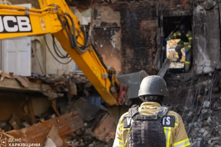 Rescuers of Ukraine’s State Emergency Service at the apartment block hit by a Russian missile in Kharkiv