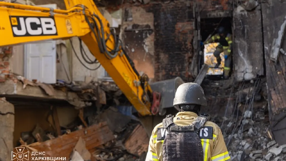 Rescuers of Ukraine’s State Emergency Service at the apartment block hit by a Russian missile in Kharkiv