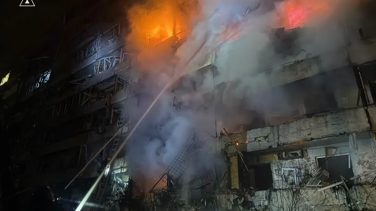Ukrainian emergency service firefighters at a damaged apartment block in Kyiv