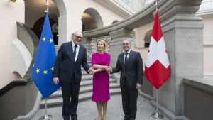 Kaja Kallas shaking hands with Swiss and EU officials in front of the EU and Swiss flags in Zurich