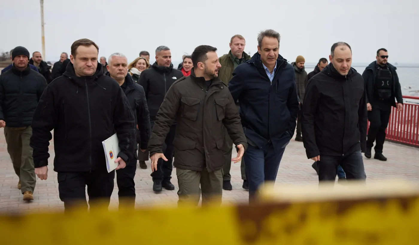 Kyriakos Mitsotakis and Volodymyr Zelensky walking in a port among members of the delegations