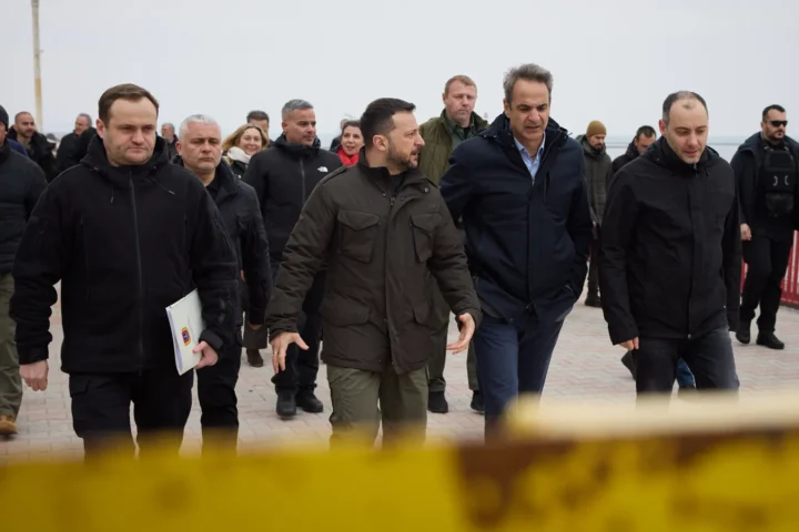Kyriakos Mitsotakis and Volodymyr Zelensky walking in a port among members of the delegations