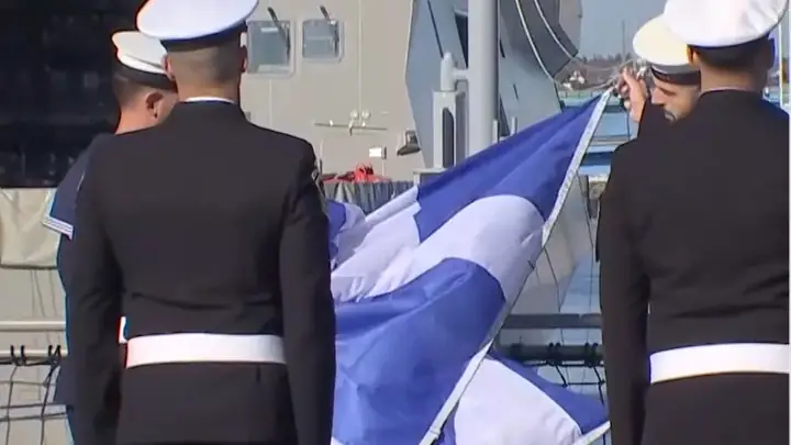 Hellenic Navy personnel raise the Greek flag on the deck of the frigate Nearchos at Lorient
