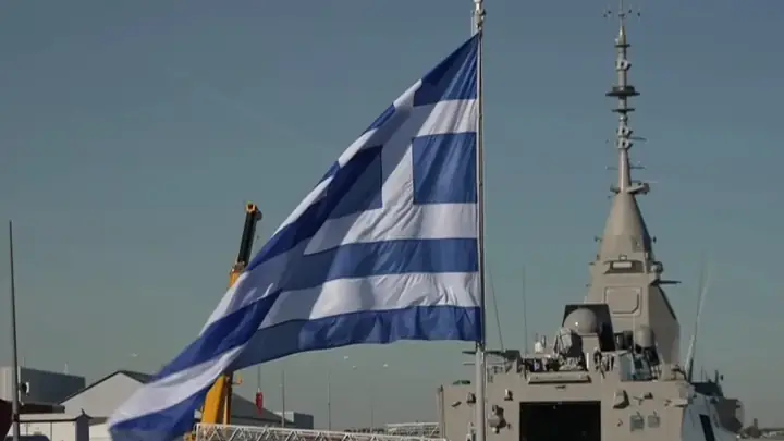 The Greek flag flies from the mast of the frigate Nearchos, with the FDI sensor mast in the background